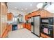 Functional kitchen with wood cabinets, stainless steel refrigerator, and arched entryway to living area at 7216 E Aurora --, Scottsdale, AZ 85266