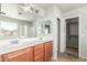 Bathroom with dual sinks, vanities, a large mirror, and a walk-in closet at 7622 S 69Th Dr, Laveen, AZ 85339