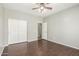 Bedroom with hardwood floors, a ceiling fan, closet and white doors at 7622 S 69Th Dr, Laveen, AZ 85339