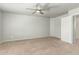 Large bedroom with neutral colored carpet, ceiling fan, and white door at 7622 S 69Th Dr, Laveen, AZ 85339