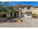 Charming two-story home featuring a stone-accented entry, a two-car garage, and a well-maintained front yard at 7622 S 69Th Dr, Laveen, AZ 85339