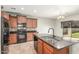 Kitchen island features a sink and faucet with dark granite countertops and wooden cabinetry at 7622 S 69Th Dr, Laveen, AZ 85339