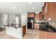 Open kitchen with black appliances, wood cabinets, granite counters, tile backsplash, and a center island with a breakfast bar at 7622 S 69Th Dr, Laveen, AZ 85339
