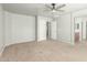 Spacious main bedroom with neutral carpet, a ceiling fan, and an en-suite bathroom for ultimate relaxation at 7622 S 69Th Dr, Laveen, AZ 85339
