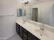 Bathroom featuring dual sinks, quartz countertops, dark cabinetry, and a large mirror at 7924 S 70Th Ln, Laveen, AZ 85339