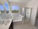Bright bathroom with tub, separate shower with glass door, and sink with a view to the outside at 7924 S 70Th Ln, Laveen, AZ 85339