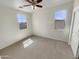 Well-lit bedroom featuring two windows and a ceiling fan at 7924 S 70Th Ln, Laveen, AZ 85339