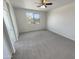 Spacious bedroom featuring neutral carpeting and a ceiling fan with a window view at 7924 S 70Th Ln, Laveen, AZ 85339