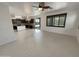 Bright living area with tile floors, a ceiling fan, and an adjacent kitchen with a central island at 7924 S 70Th Ln, Laveen, AZ 85339