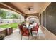A covered outdoor dining area with a ceiling fan, offering a view of the backyard and barbecue area at 7971 W Montebello Ave, Glendale, AZ 85303