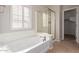 Bathroom featuring a soaking tub and glass enclosed shower at 901 S Storment Ln, Gilbert, AZ 85296