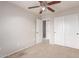 Bedroom with neutral carpeting, ceiling fan, a double door closet, and a door leading to the bathroom at 901 S Storment Ln, Gilbert, AZ 85296