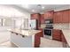 Bright kitchen features granite counters, stainless appliances, and cherry wood cabinetry at 901 S Storment Ln, Gilbert, AZ 85296