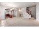 Open-concept living room featuring carpet, an arched entryway to the kitchen, and staircase access at 901 S Storment Ln, Gilbert, AZ 85296