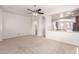 Open-concept living room with carpet, a ceiling fan, and an arched entryway to the bathroom at 901 S Storment Ln, Gilbert, AZ 85296