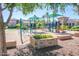 Community playground featuring modern play structures and sun shades in a landscaped setting at 901 S Storment Ln, Gilbert, AZ 85296