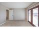 A well lit, carpeted empty room with a double door leading to a view at 9735 W Ironwood Dr # A, Peoria, AZ 85345