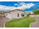 Spacious backyard featuring green grass, desert landscaping, and a view of the home's exterior at 10064 E Kilarea Ave, Mesa, AZ 85209