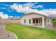A well-maintained backyard featuring a lush lawn, desert landscaping, and a covered patio area at 10064 E Kilarea Ave, Mesa, AZ 85209