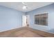 Bright bedroom with carpet flooring, neutral walls, and a door leading to an adjacent room at 10064 E Kilarea Ave, Mesa, AZ 85209
