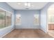 Well-lit bedroom with plush carpet, blue walls, and large windows overlooking a residential area at 10064 E Kilarea Ave, Mesa, AZ 85209