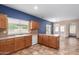 Well-lit kitchen featuring tile floors, wood cabinets, and neutral countertops with a bright window at 10064 E Kilarea Ave, Mesa, AZ 85209