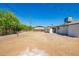 View of the backyard featuring a dirt lot, chainlink fence, and a patio area at 1012 E Estevan Ave, Apache Junction, AZ 85119