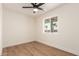 Bedroom with hardwood flooring, a modern ceiling fan, and a window view of palm trees at 1012 E Estevan Ave, Apache Junction, AZ 85119
