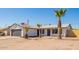 A well-maintained single-story home with desert landscaping that includes palm trees and an American flag at 1012 E Estevan Ave, Apache Junction, AZ 85119