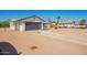 Single-story home with a gray garage door, desert landscaping, and a spacious driveway for easy parking at 1012 E Estevan Ave, Apache Junction, AZ 85119