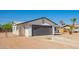 Lovely home featuring a gray garage door, low-maintenance landscaping, and clear blue skies above at 1012 E Estevan Ave, Apache Junction, AZ 85119