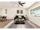 Bright living room with a modern ceiling fan, a comfortable sofa, and a stylish coffee table with decor at 1012 E Estevan Ave, Apache Junction, AZ 85119