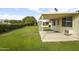 Large backyard with a covered patio, lawn, and manicured hedges at 10927 W Peoria Ave, Sun City, AZ 85351
