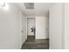 Bright hallway featuring sleek hardwood floors and neutral paint with doors along each side at 10927 W Peoria Ave, Sun City, AZ 85351