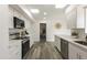 Updated kitchen features white cabinets, modern stainless steel appliances, and neutral decor at 10927 W Peoria Ave, Sun City, AZ 85351