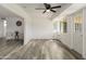 Bright living room featuring hardwood floors, a ceiling fan and an exterior door with windows at 10927 W Peoria Ave, Sun City, AZ 85351