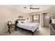 Bright bedroom with neutral tones, ceiling fan, plush carpet and an ensuite bathroom that features sliding mirrored closet doors at 1211 N Miller Rd # 213, Scottsdale, AZ 85257