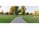 Picturesque park featuring a paved path, grassy areas, mature trees and a tranquil pond for outdoor recreation at 1211 N Miller Rd # 213, Scottsdale, AZ 85257