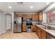 Well-lit kitchen showcasing stainless steel appliances, oak cabinets and tile flooring at 12427 W El Nido Ln, Litchfield Park, AZ 85340