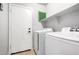 This laundry room includes a full-size washer and dryer and shelving at 12427 W El Nido Ln, Litchfield Park, AZ 85340