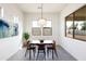 Bright dining area features modern light fixture, large windows, and decorative painting at 14407 N 75Th Dr, Peoria, AZ 85381