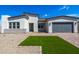 Modern home exterior with a gray garage door and landscaped front yard at 14407 N 75Th Dr, Peoria, AZ 85381
