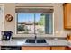 Kitchen sink with view of backyard, stainless steel sink, stone countertops, and modern fixtures at 1557 W Laurel Greens Ct, Anthem, AZ 85086