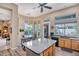 Open concept kitchen with island seating, views to the dining nook and backyard, and stainless steel appliances at 1557 W Laurel Greens Ct, Anthem, AZ 85086