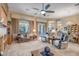 Open-concept living room offering a ceiling fan, comfortable furniture, and access to the backyard at 1557 W Laurel Greens Ct, Anthem, AZ 85086