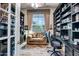 A well-lit office with a couch and extensive bookshelves at 1557 W Laurel Greens Ct, Anthem, AZ 85086