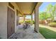 Covered patio features stone flooring and views of the lush backyard; great for entertaining and outdoor enjoyment at 1557 W Laurel Greens Ct, Anthem, AZ 85086