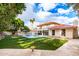 Backyard view of the home features well-manicured lawn, a pool and spa, and a covered patio at 17012 N 57Th St, Scottsdale, AZ 85254