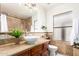 Bathroom features travertine stone walls, a wood cabinet, and vessel sink at 17012 N 57Th St, Scottsdale, AZ 85254