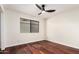 Bedroom features dark wood floors, a modern ceiling fan, and one window at 17012 N 57Th St, Scottsdale, AZ 85254